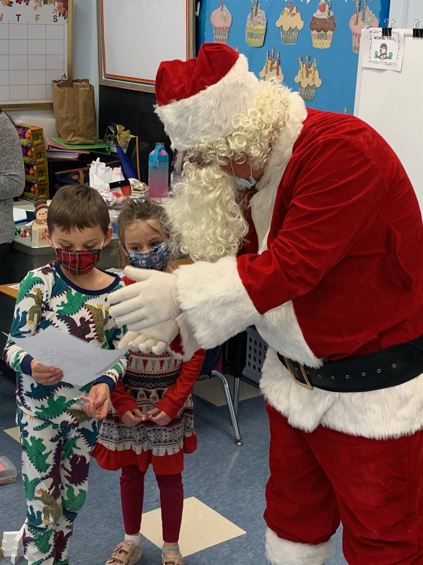 2 students hugs Santa.