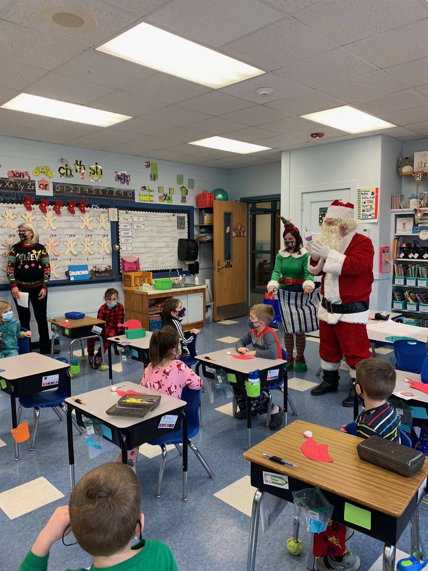 Santa arrives in a classroom of student with Elf. 