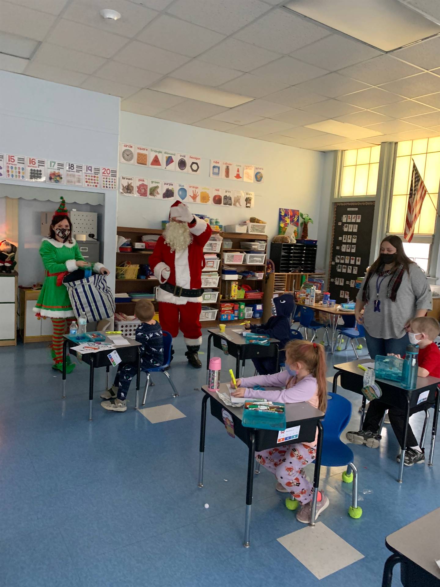 Santa talks with students with his elf. 