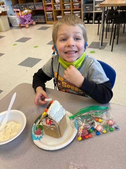 student with gingerbread house.