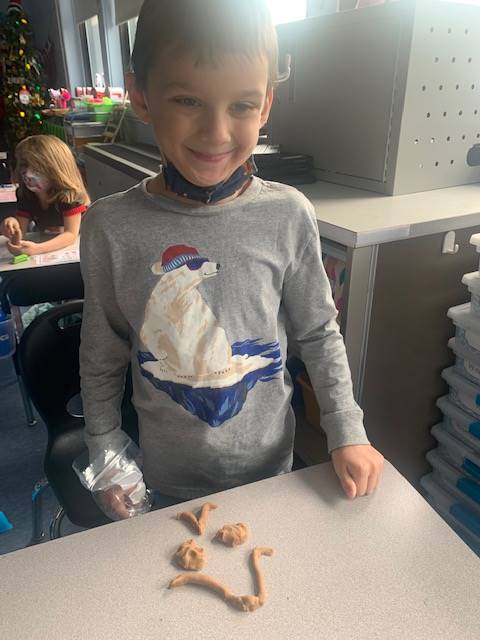 student with playdo gingerbread friend. 