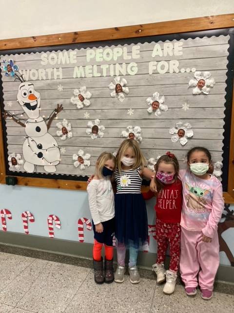 4 students in front of bulletin board with Olaf snowman
