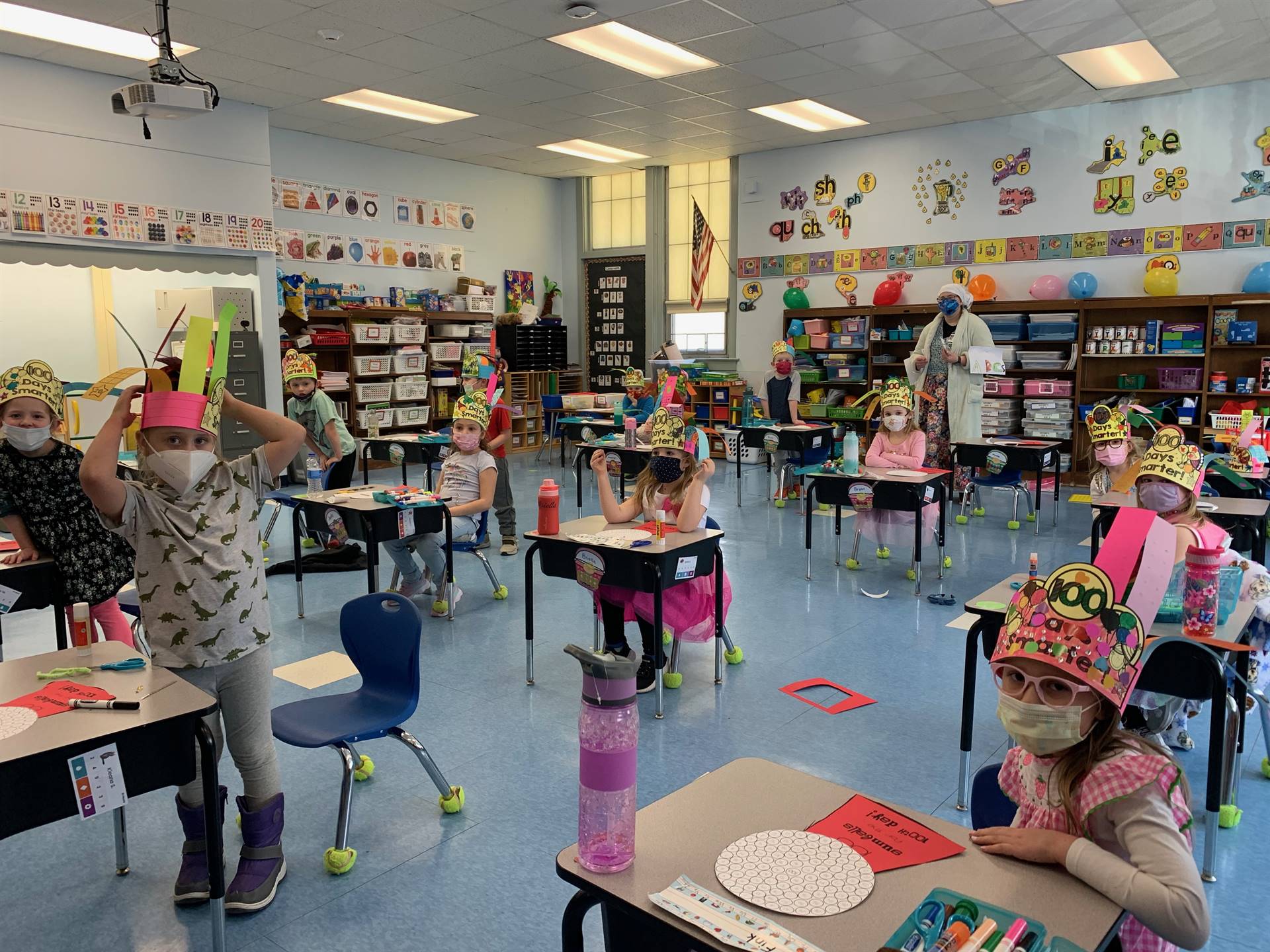 A classroom of students with 100th day celebration hats. 