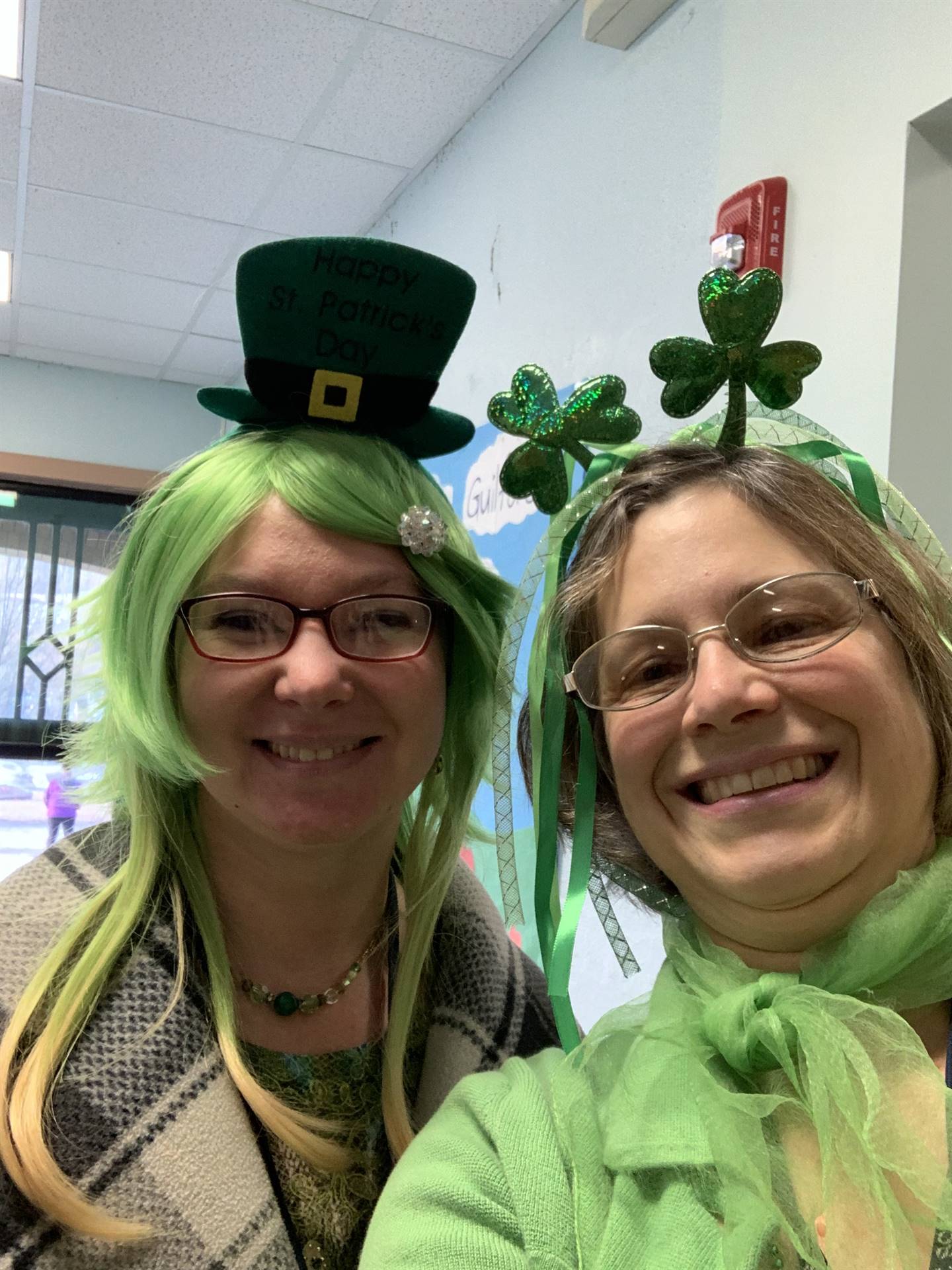 2 staff members dressed in green with green headbands