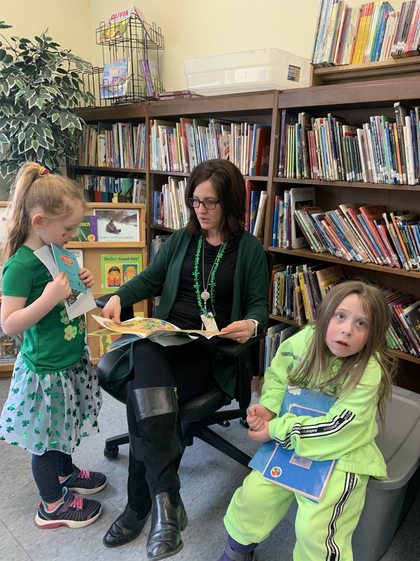 a staff member reads to 2 students