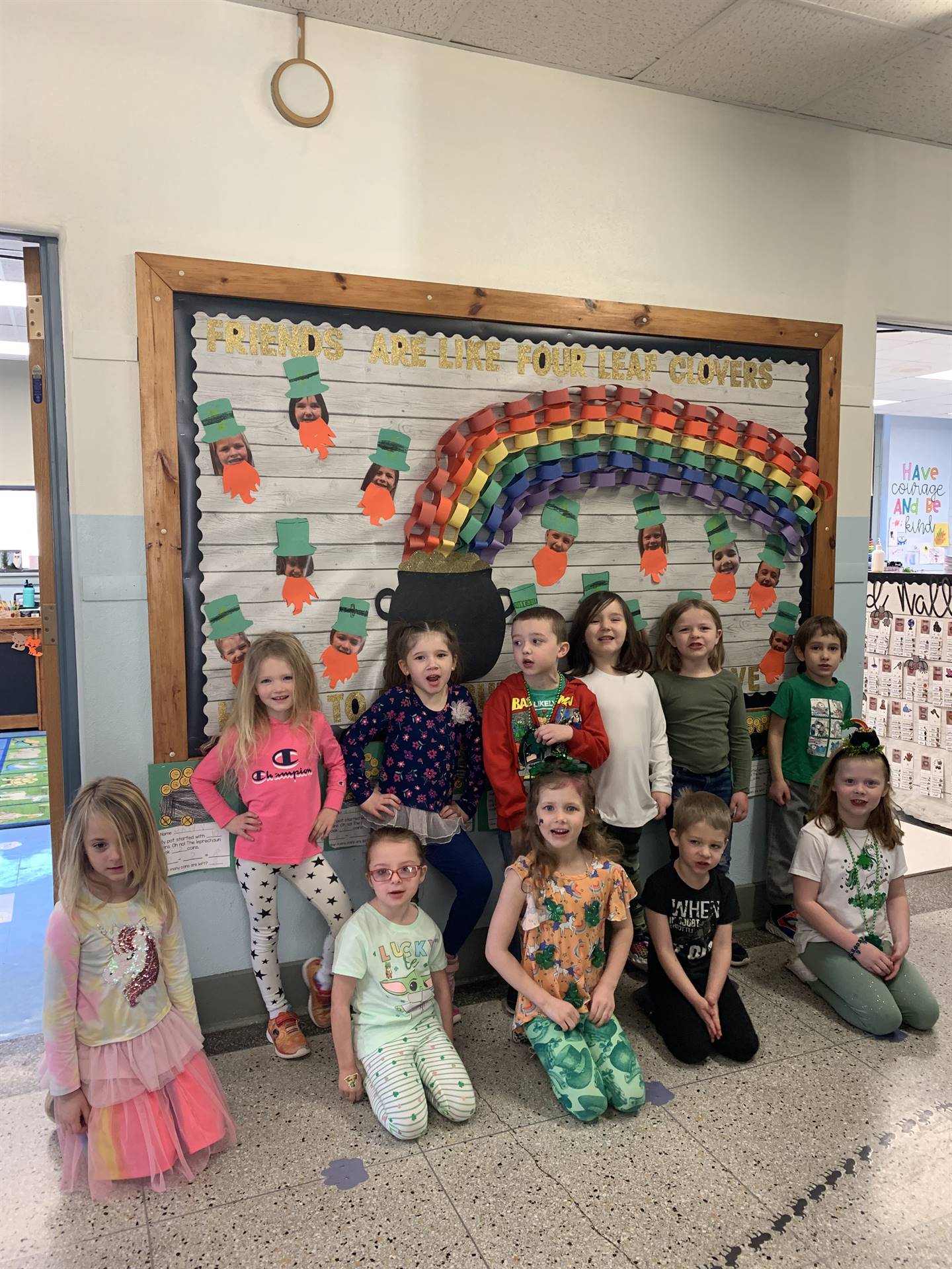 a class of students with a bulletin board with pot of gold and rainbow.