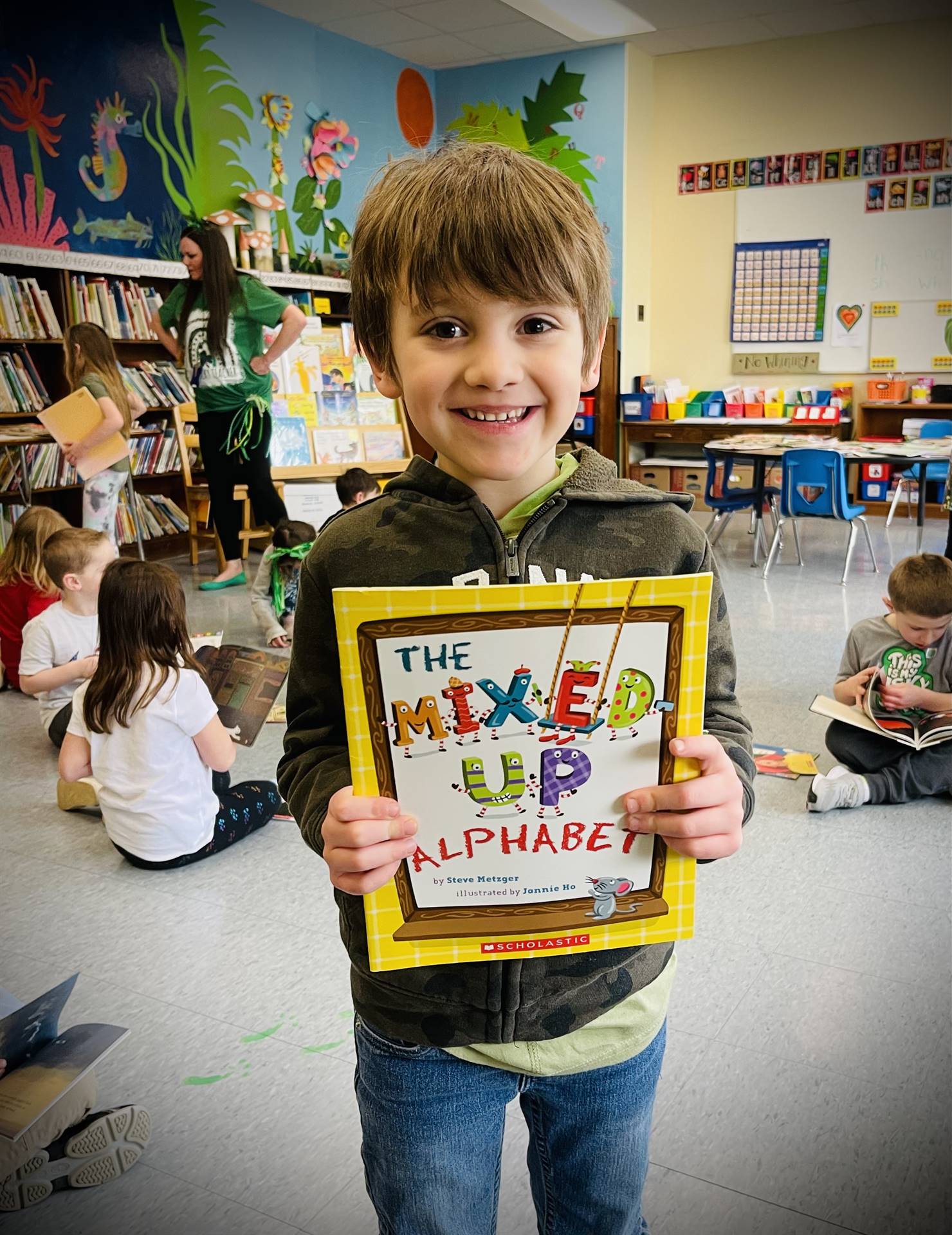 a student holds up a book, The mixed up alphabet"