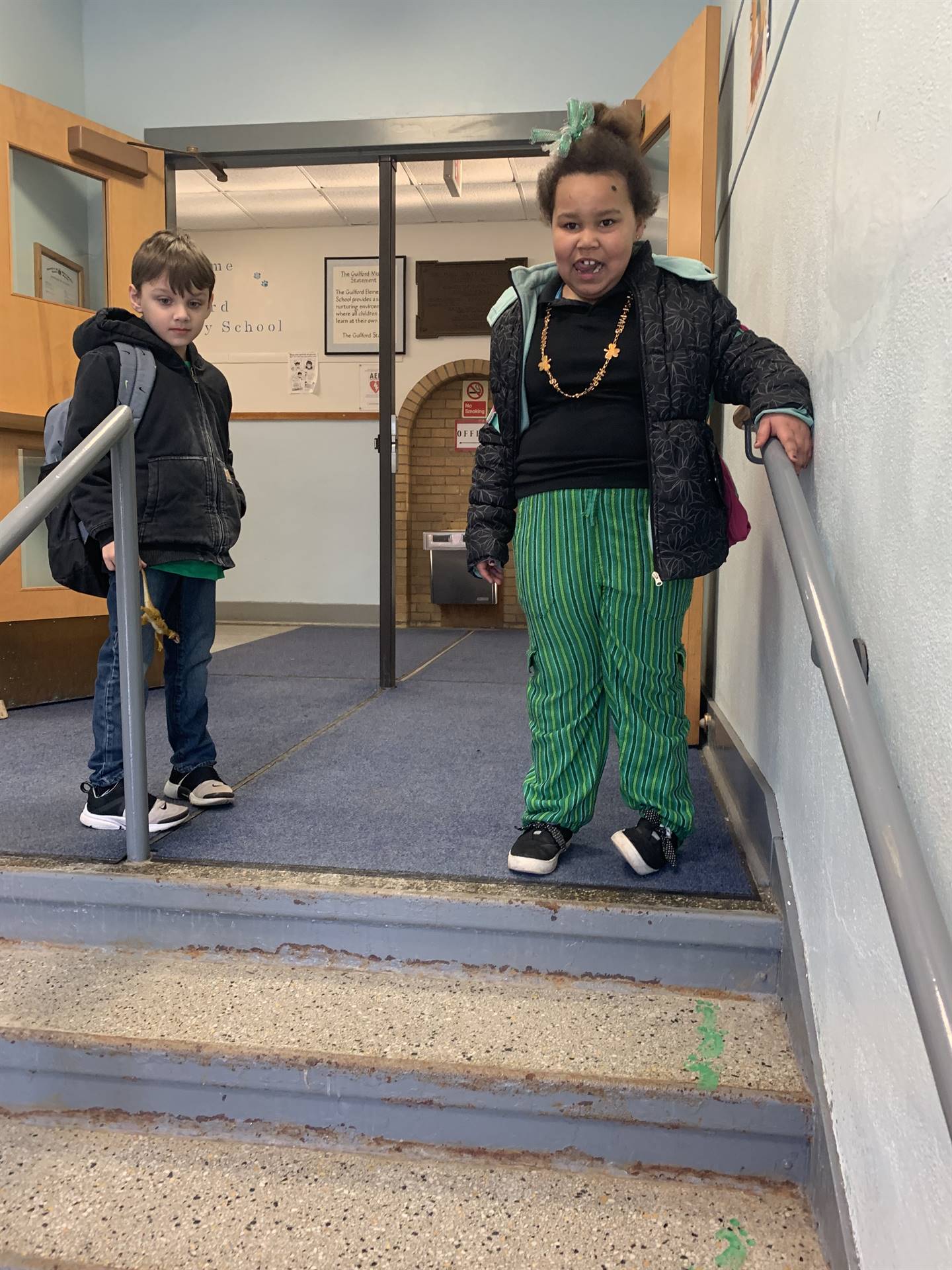 a student dressed in green coming up the stairs.