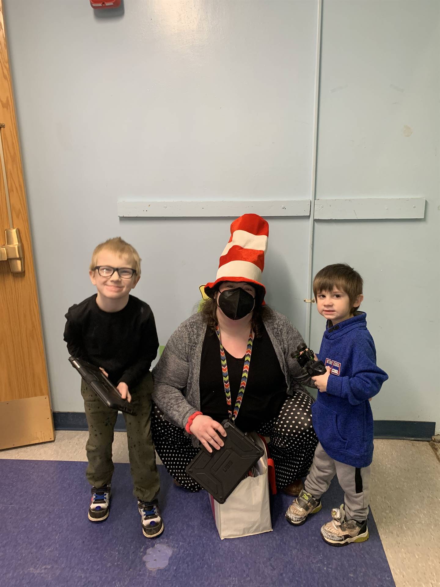 teacher with dr. Suess hat between 2 students