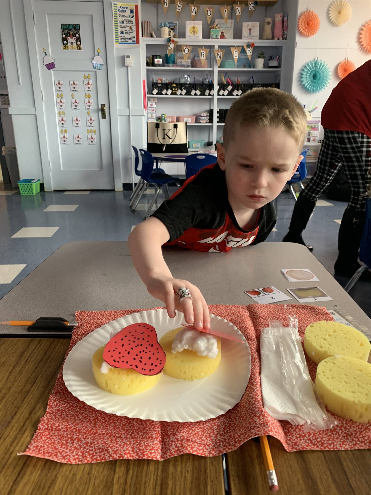 student works with group to assemble a strawberry shortcake.