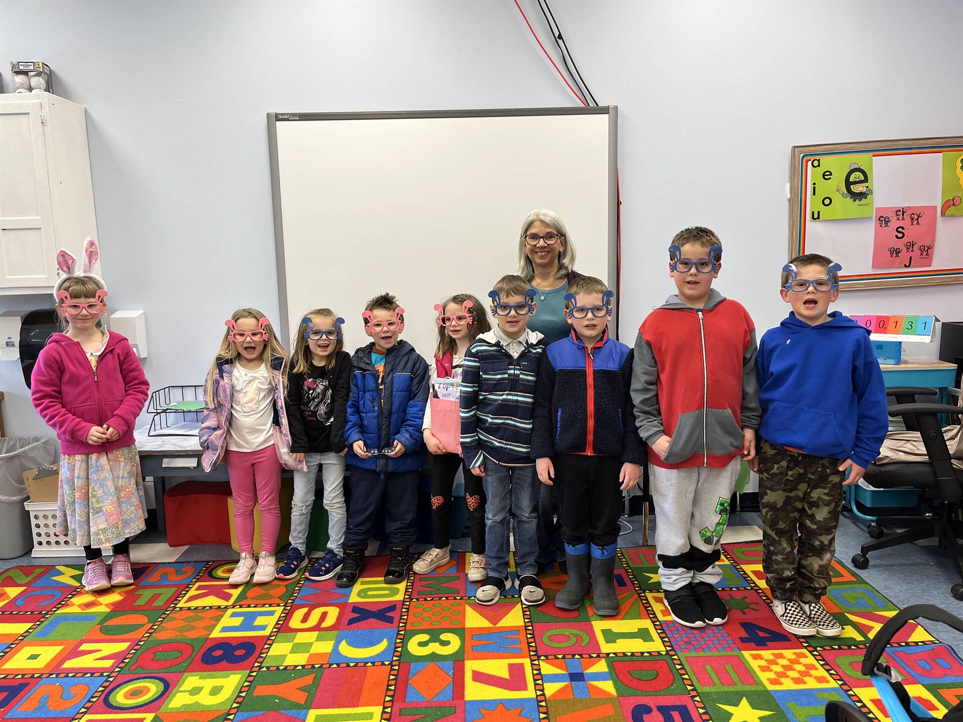 A class dressed in bunny ears and glasses with their principal