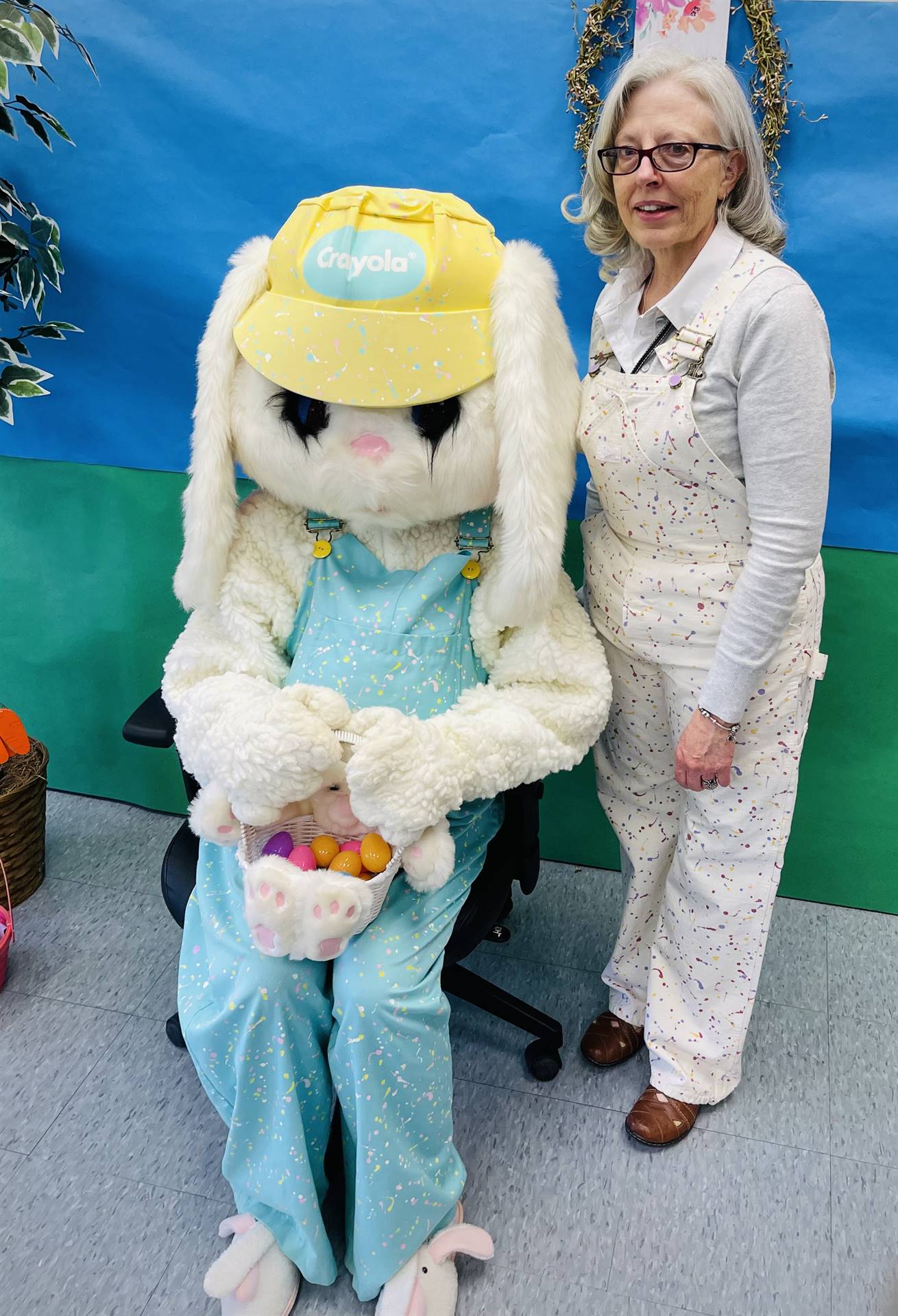 An adult stands to adult dressed up as a Spring bunny
