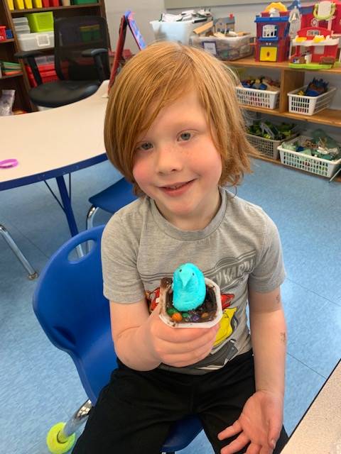a student holds up a peep in a cup