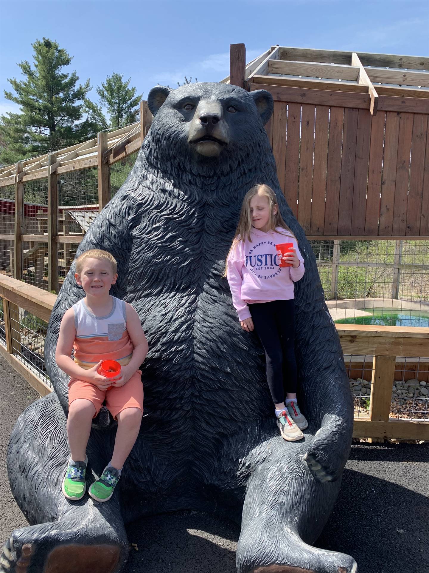 students sitting on a giant bear statue