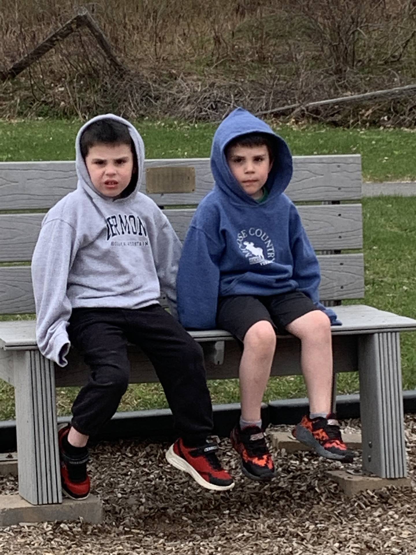 2 children sitting on a buddy bench