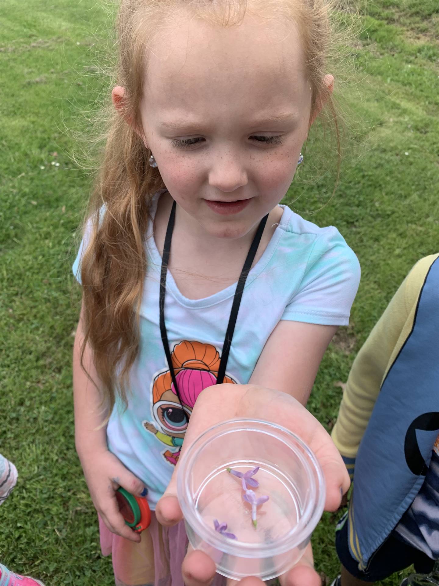 child showing a container of nature treasure
