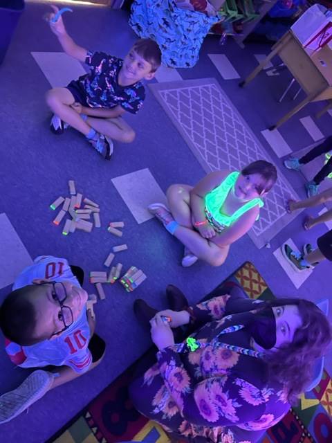 students playing glow jenga with adult