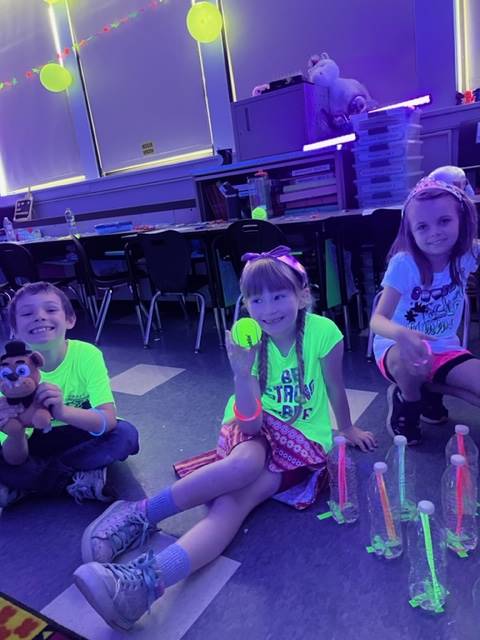 3 students glowing in fluorescent green