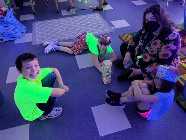 students and staff member play games for glow day