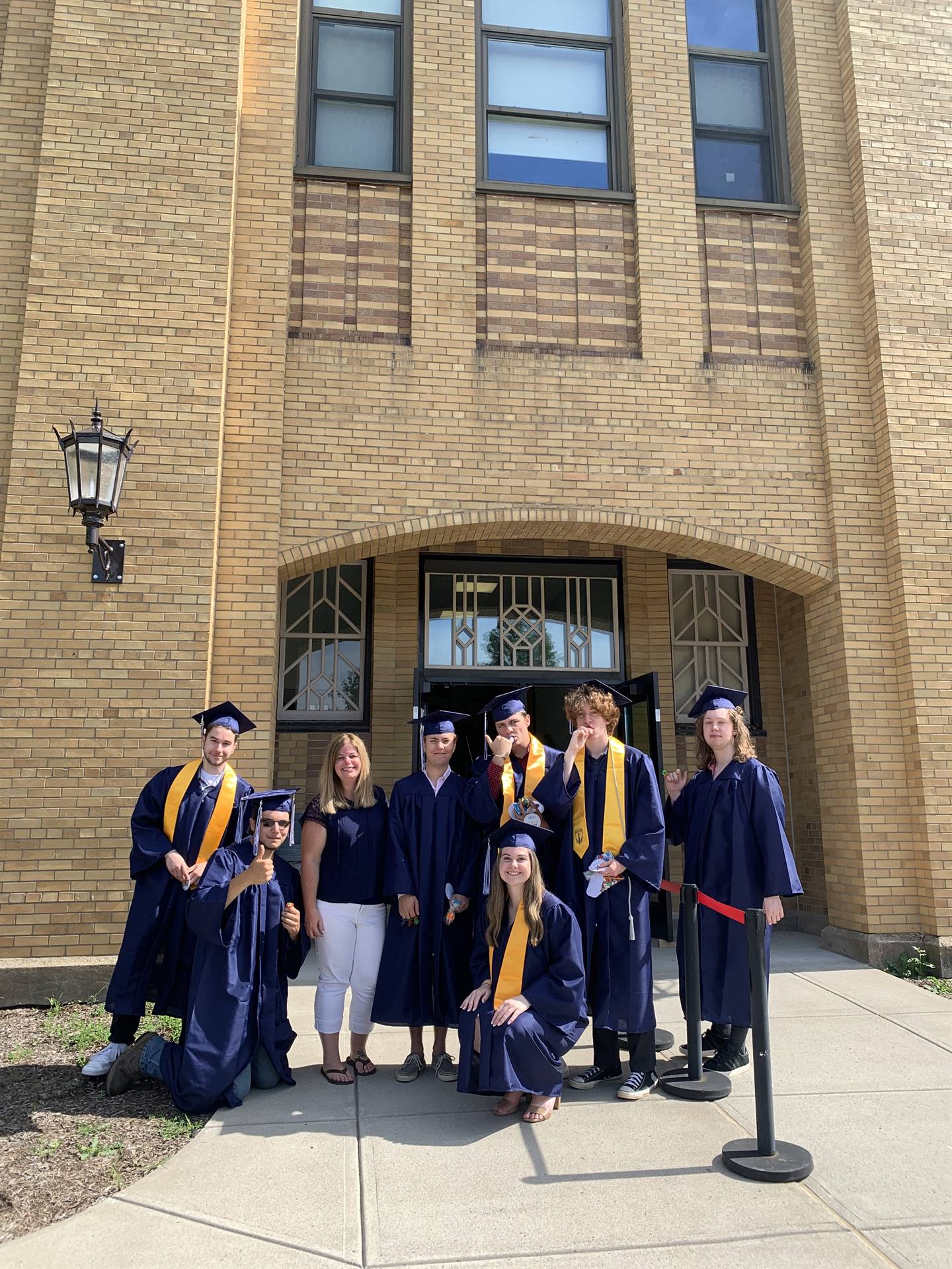 a group of high school graduates stand in front of their former primary school