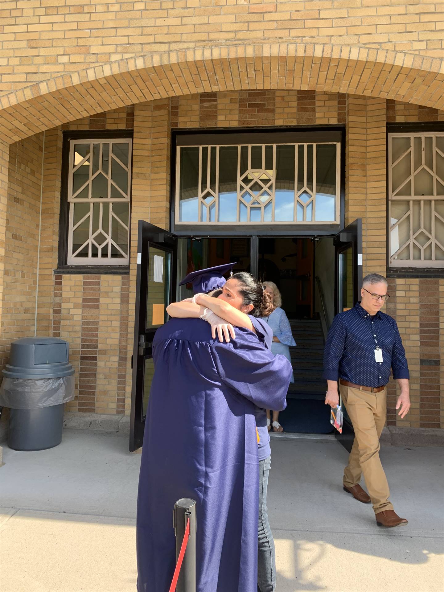 a high school graduate hugs his mother