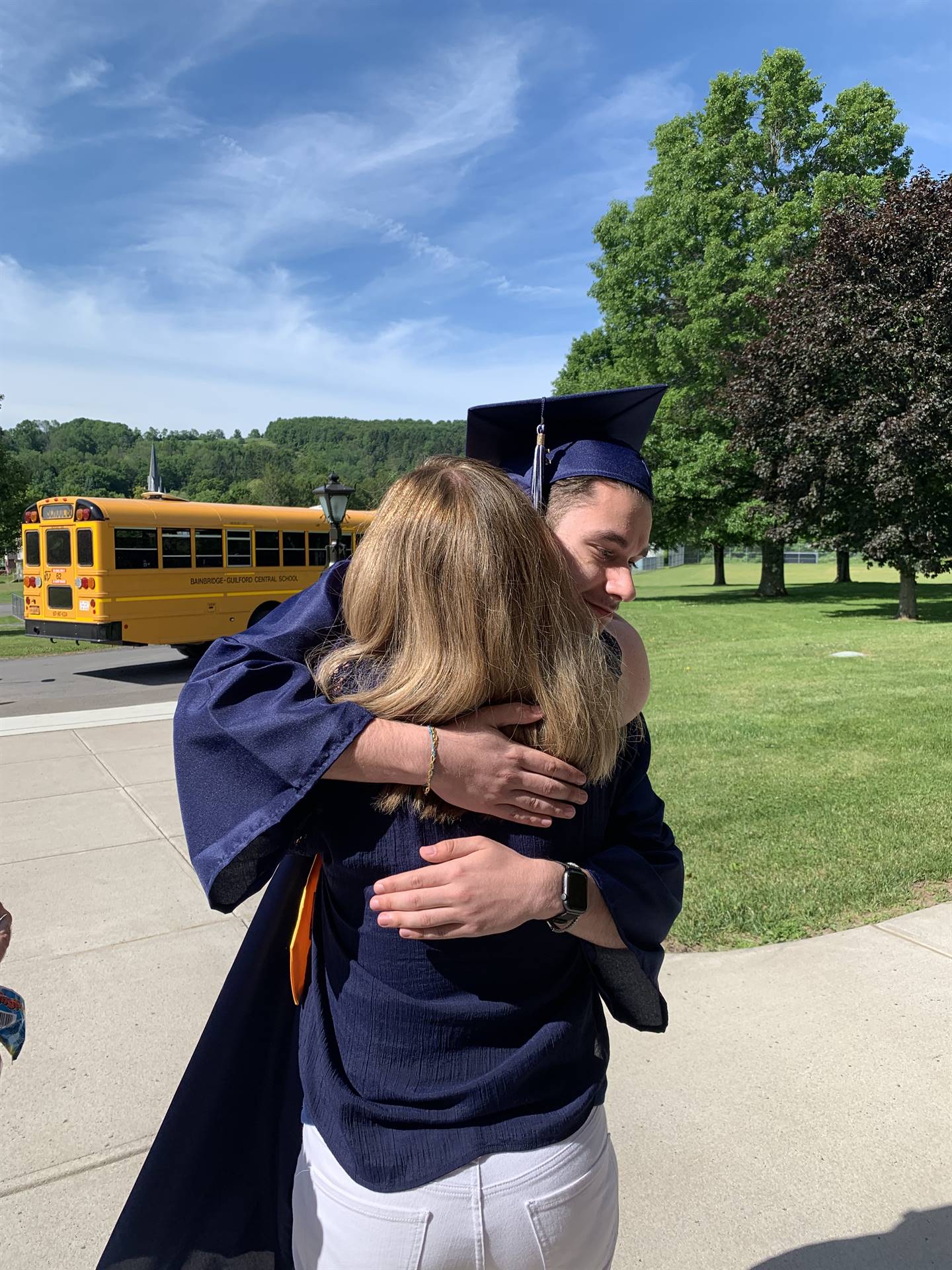 high school graduate hugs a primary school teacher
