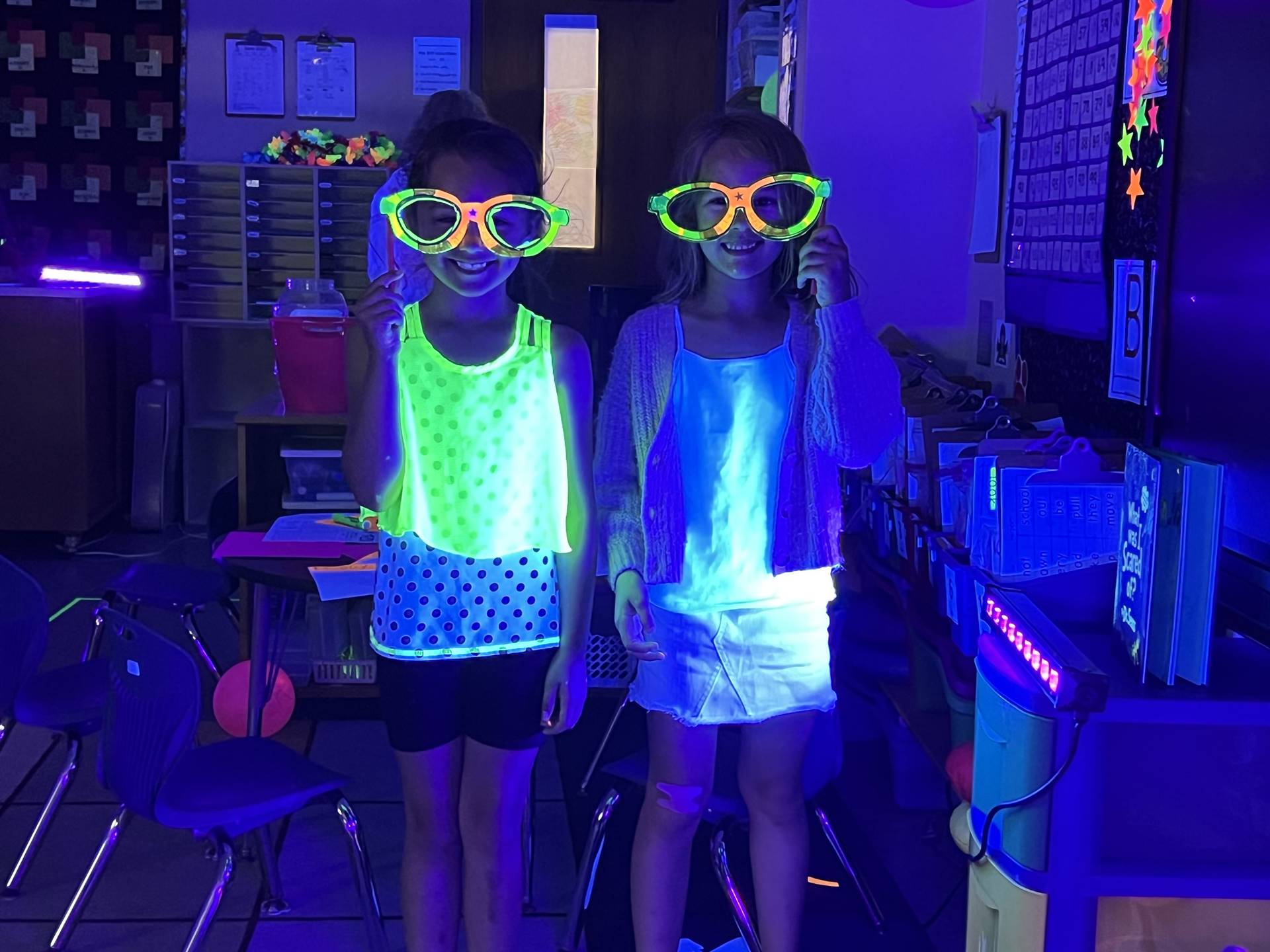 2 students with glow shirts and glasses