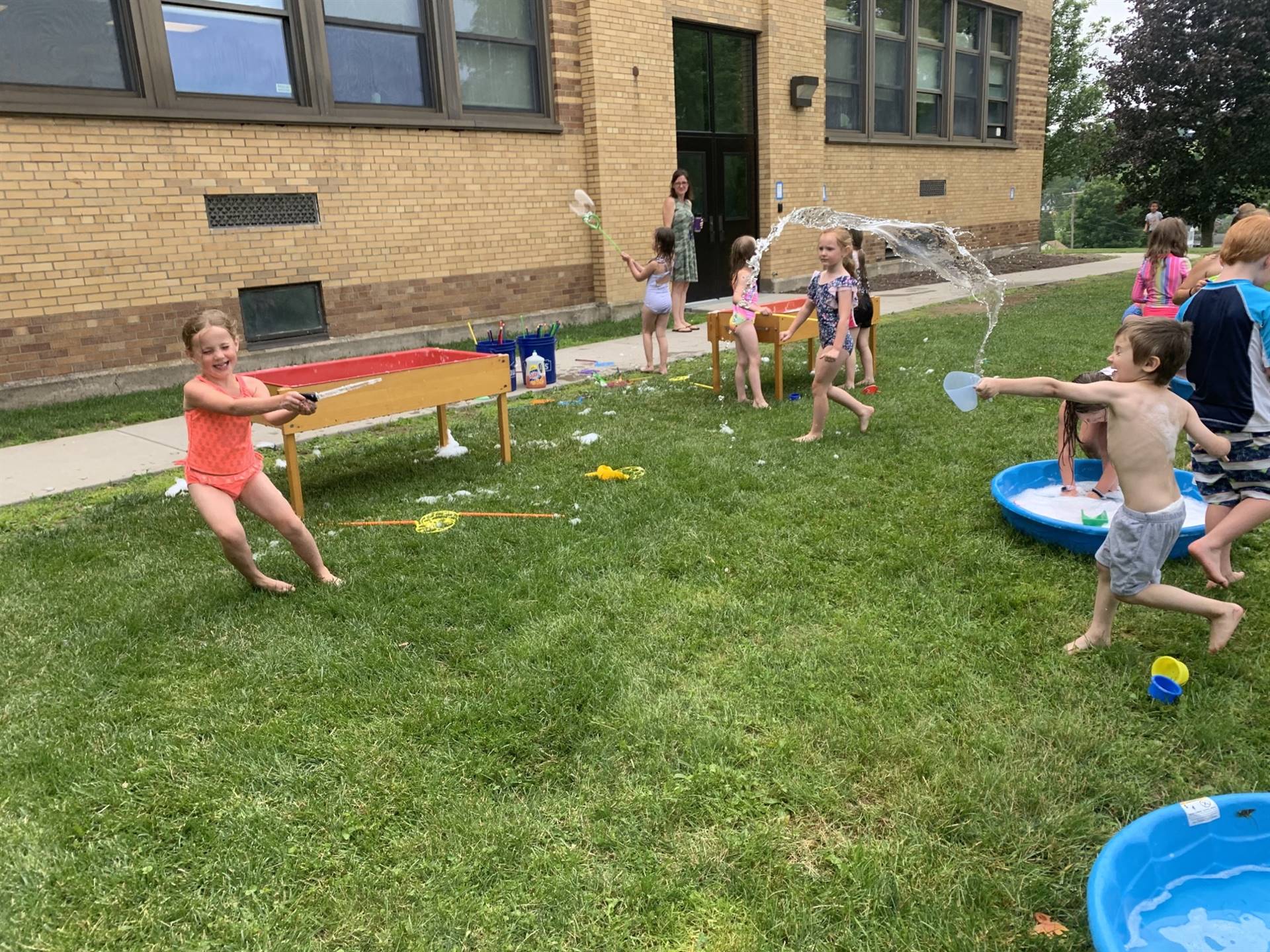 students outdoors playing in water
