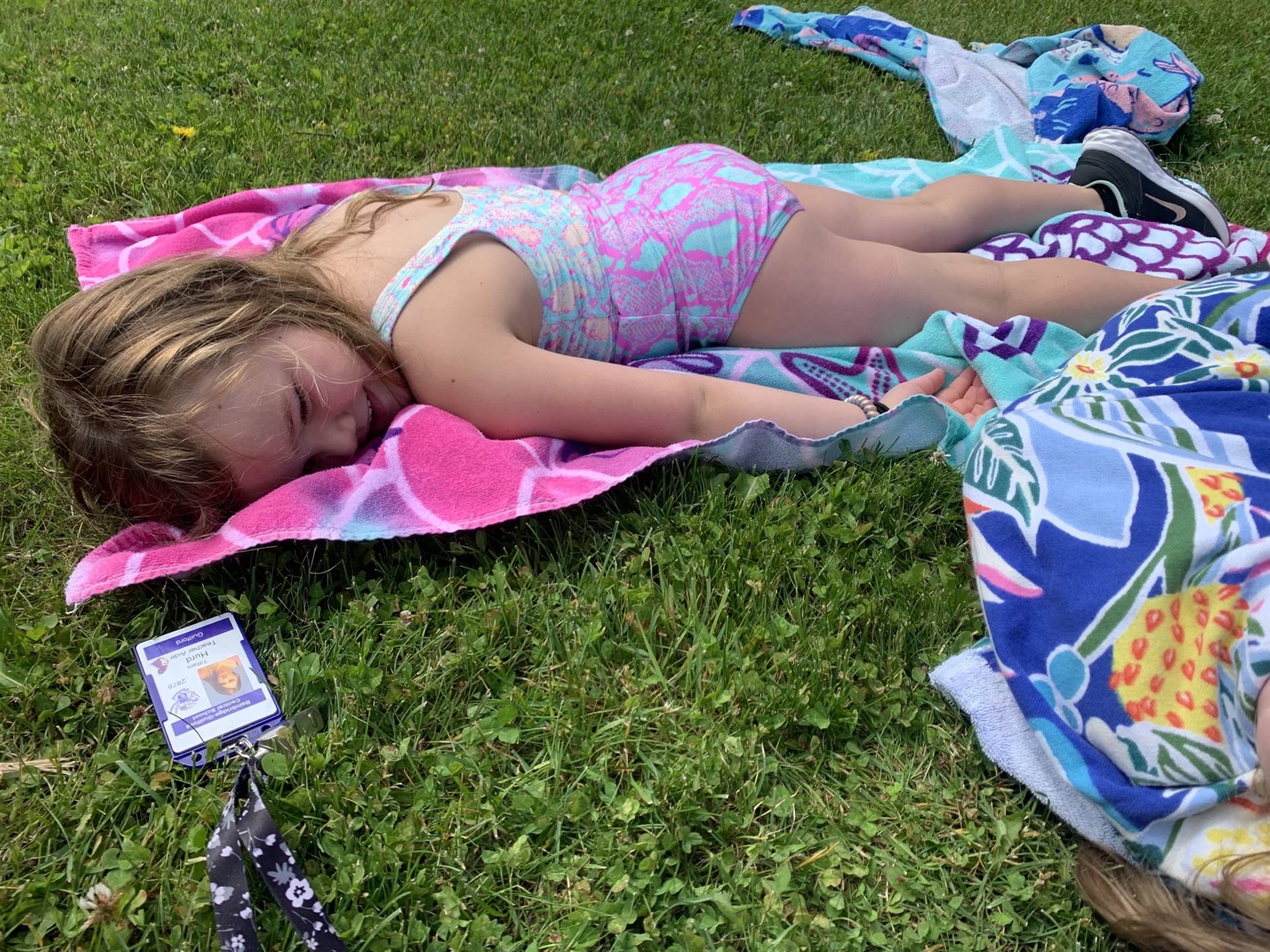 student laying on towel outside