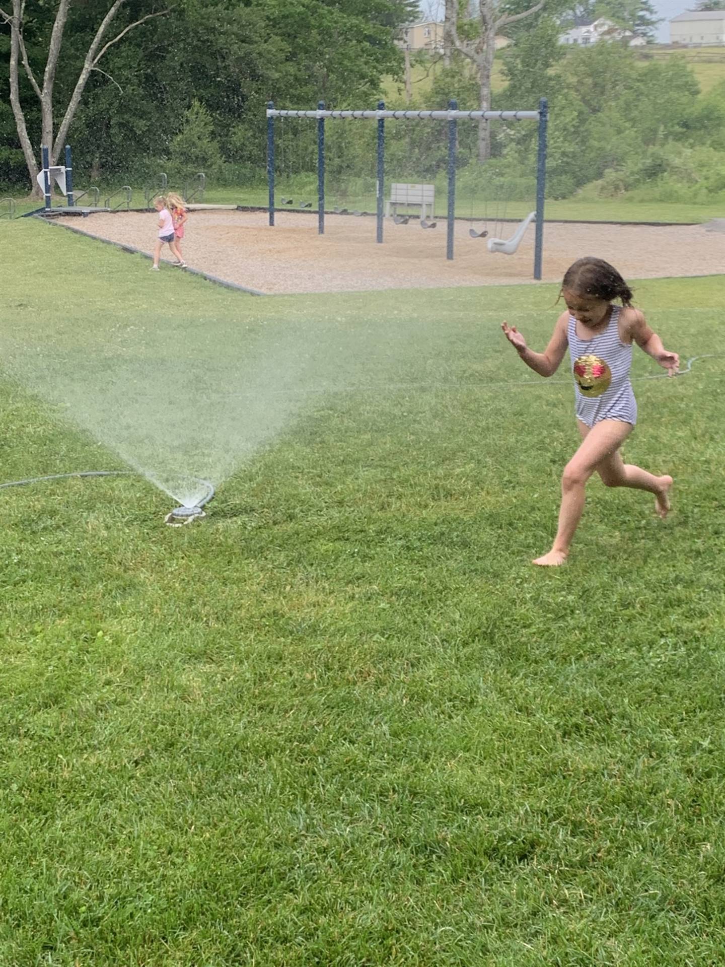 student running through a water sprinkler