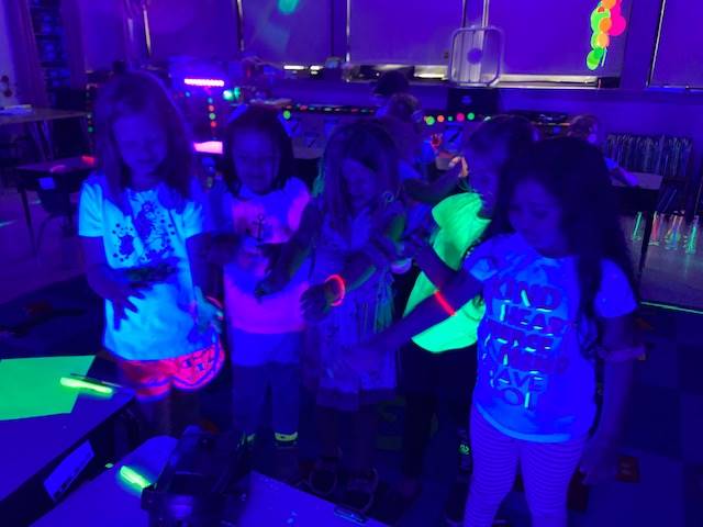 a group of students showing their glow bracelets