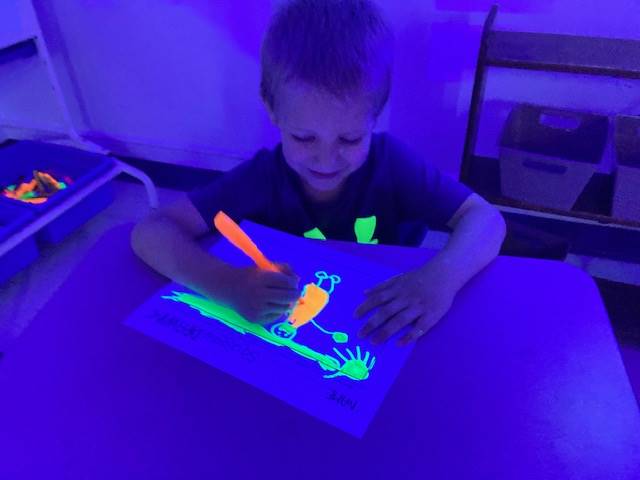 a student colors a glow day picture