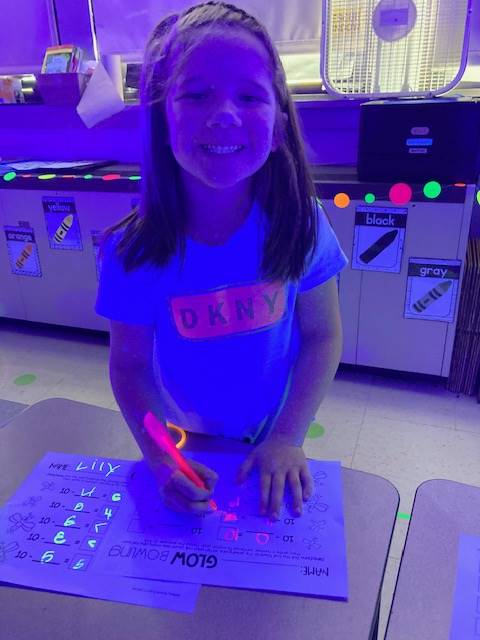 a student colors a glow day picture