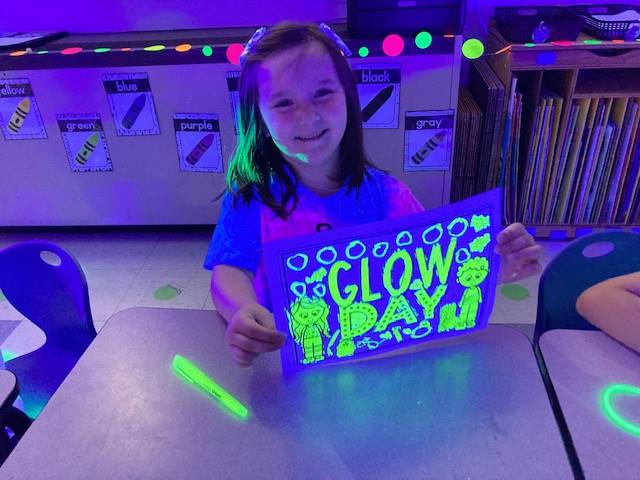 a student holds up a glow day picture