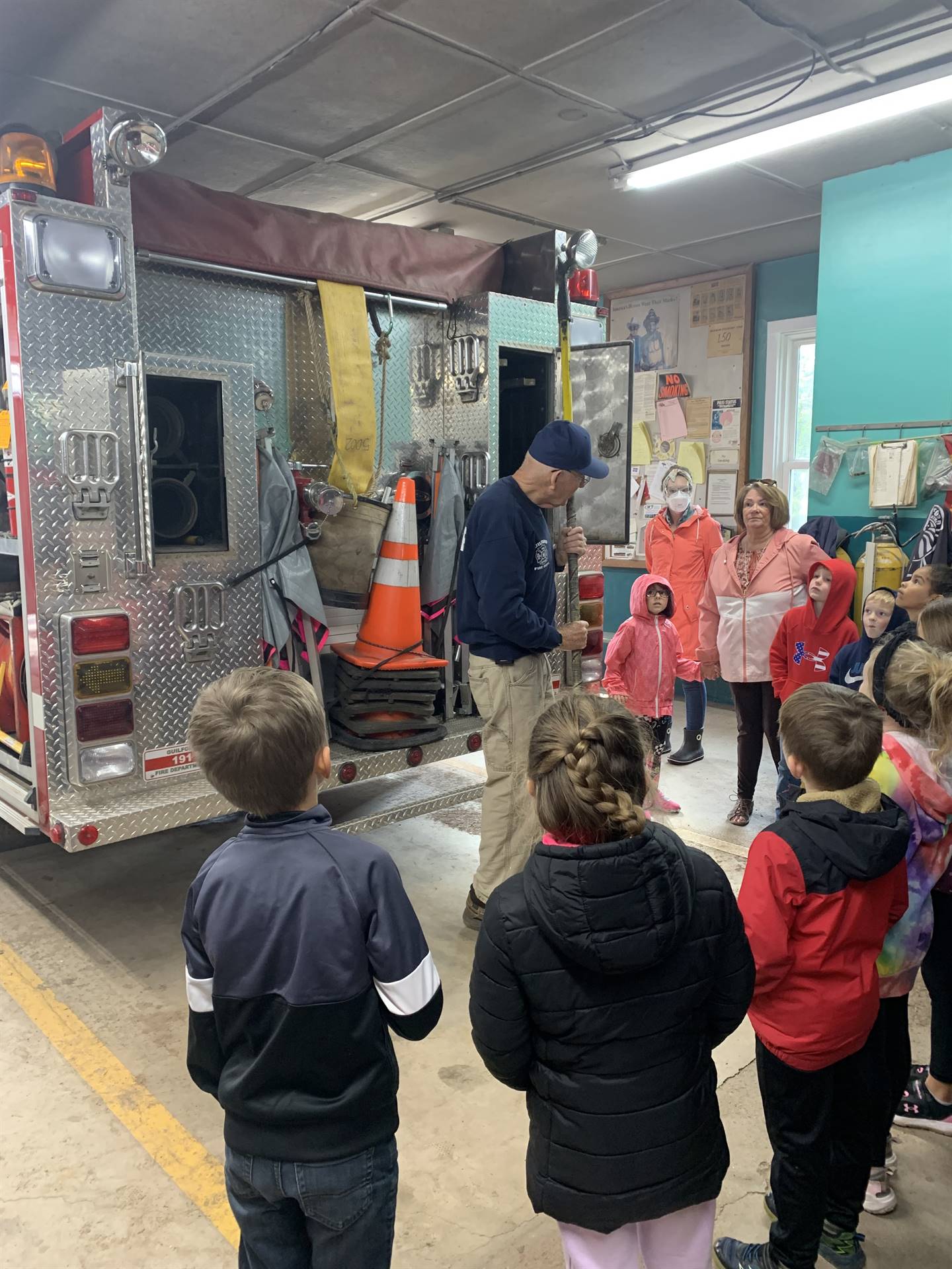 students standing listening to an adult. 