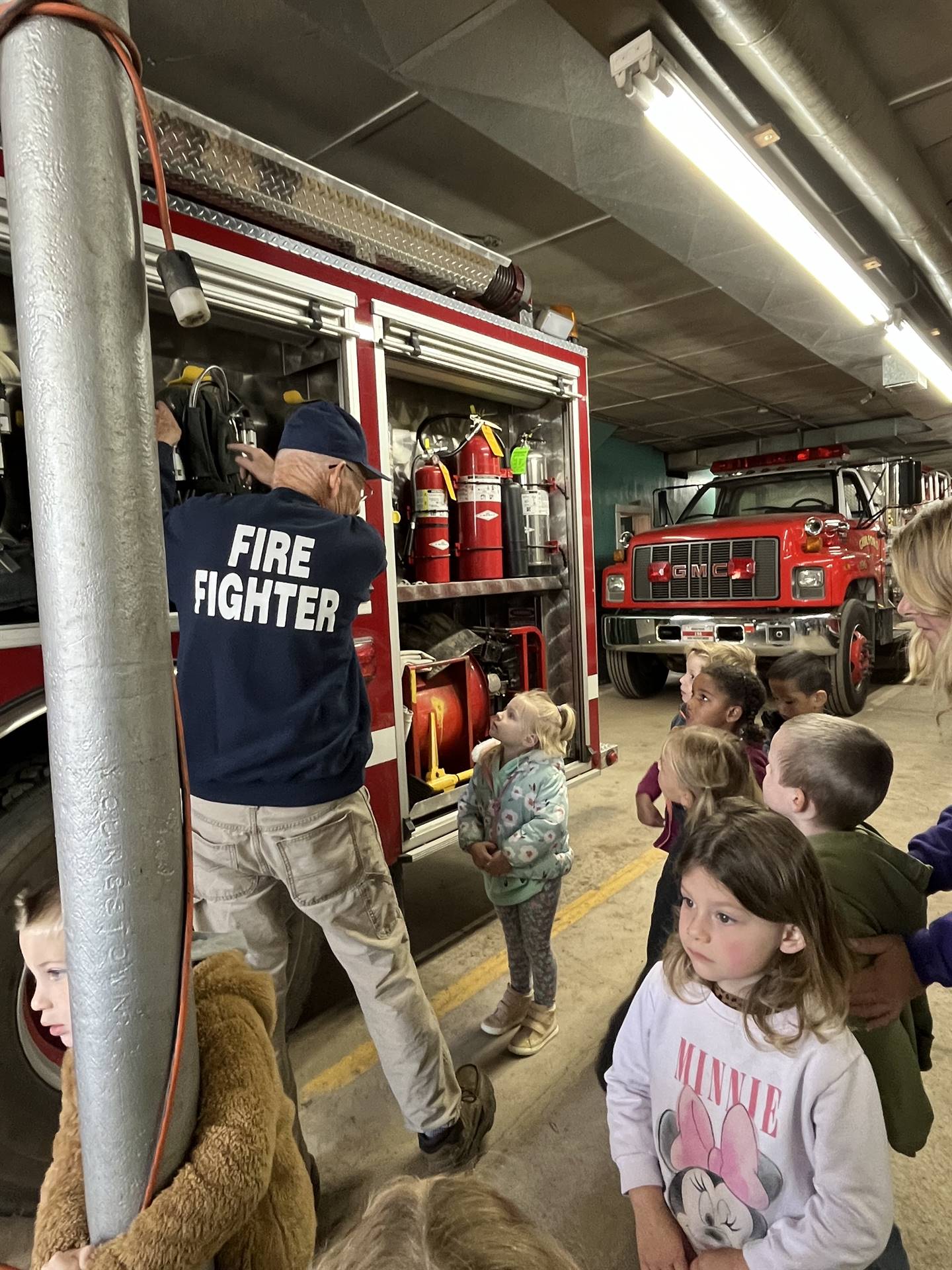 Firefighter tells students about the equipment found on a firetruck