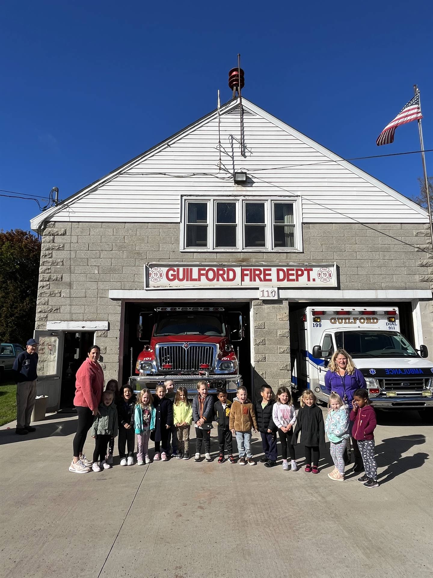 students and teachers stand in front of Guilford fire dept. 