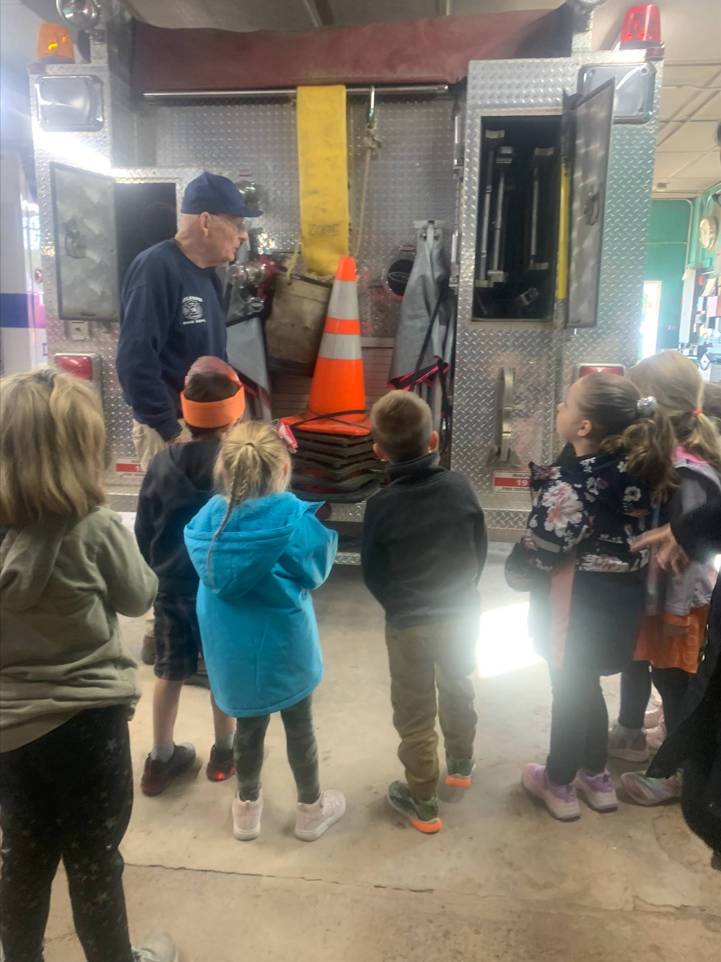 students listening to firefighter talk about fire equipment