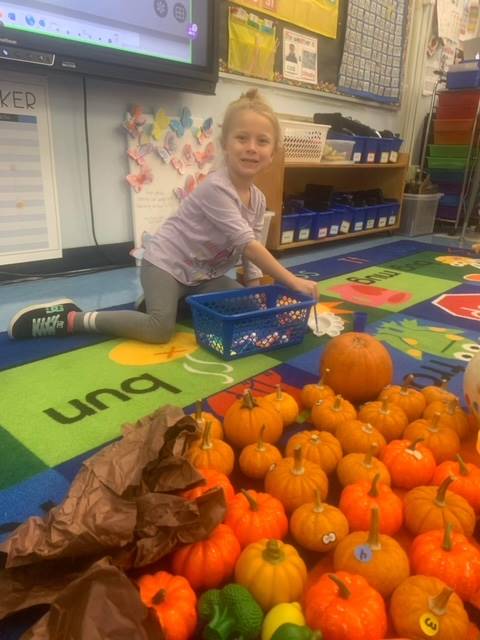 A student inside surrounded by pumpkins