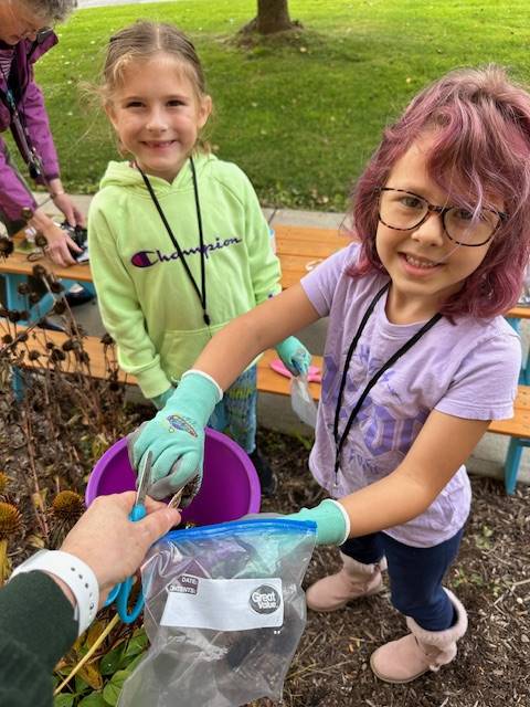 2 students filling pails outside.