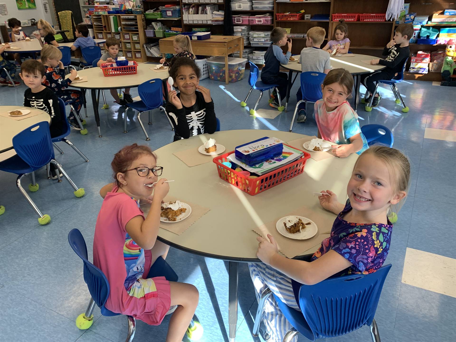 4 students at desks with pumpkin cake