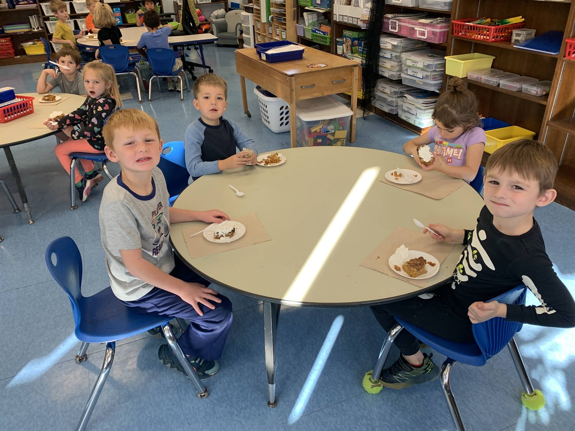 4 students at desks with pumpkin cake