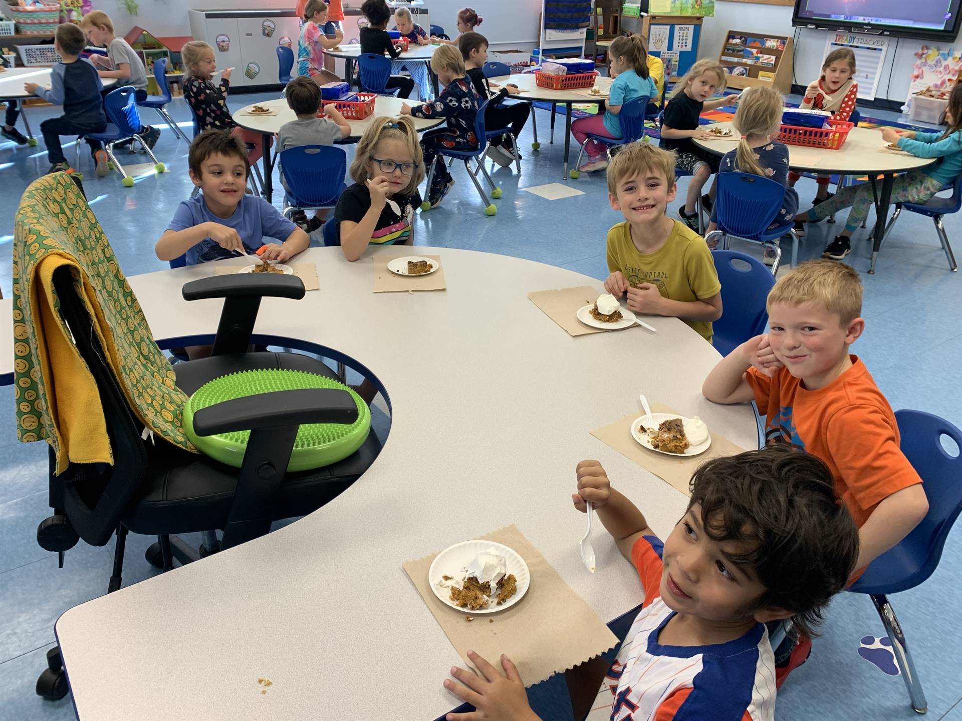 4 students at desks with pumpkin cake