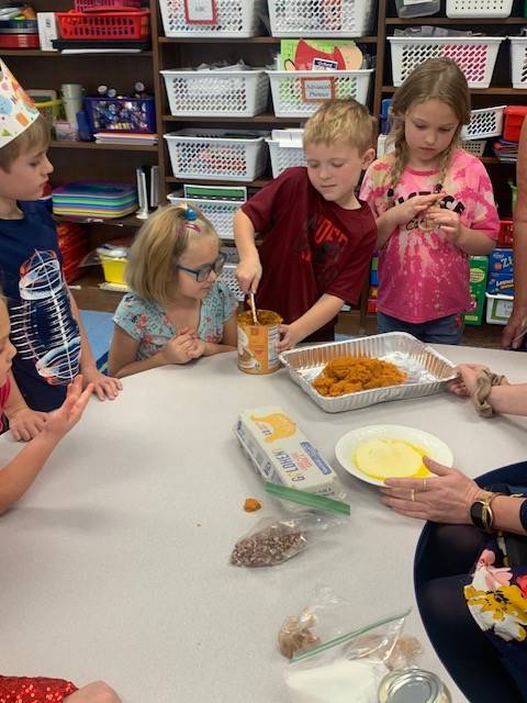 students dumping ingredients for pumpkin cake