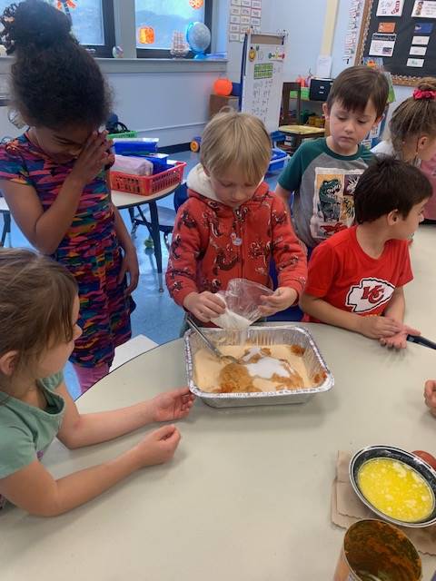 students dumping ingredients for pumpkin cake