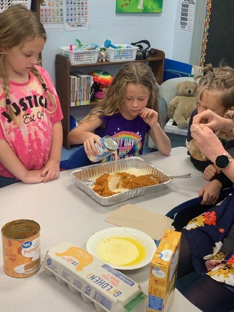 students dumping ingredients for pumpkin cake