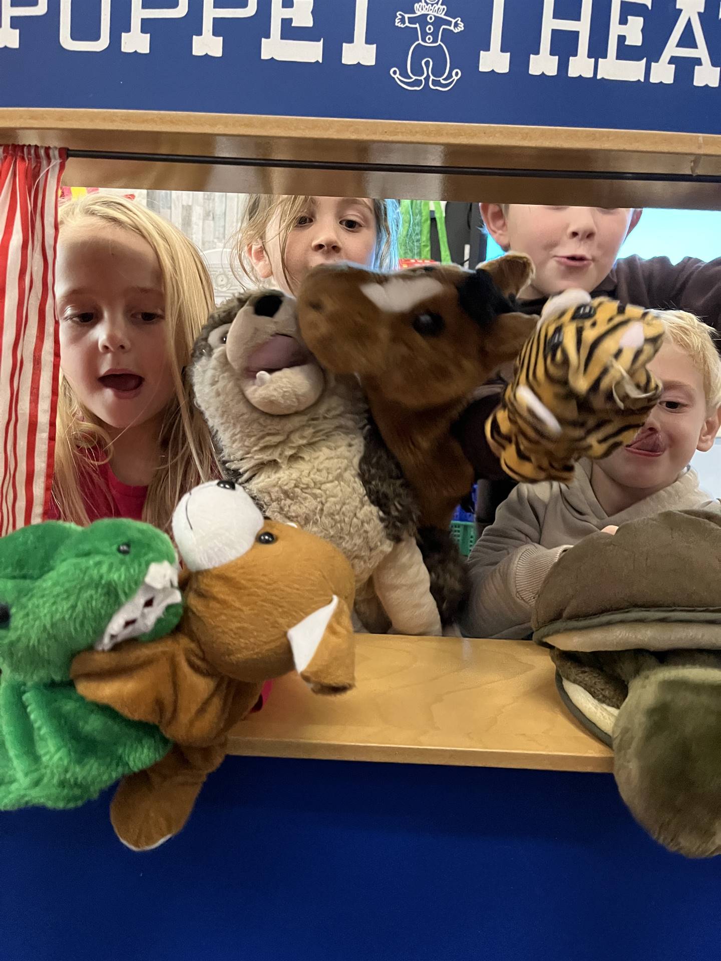 students in puppet theater with puppets