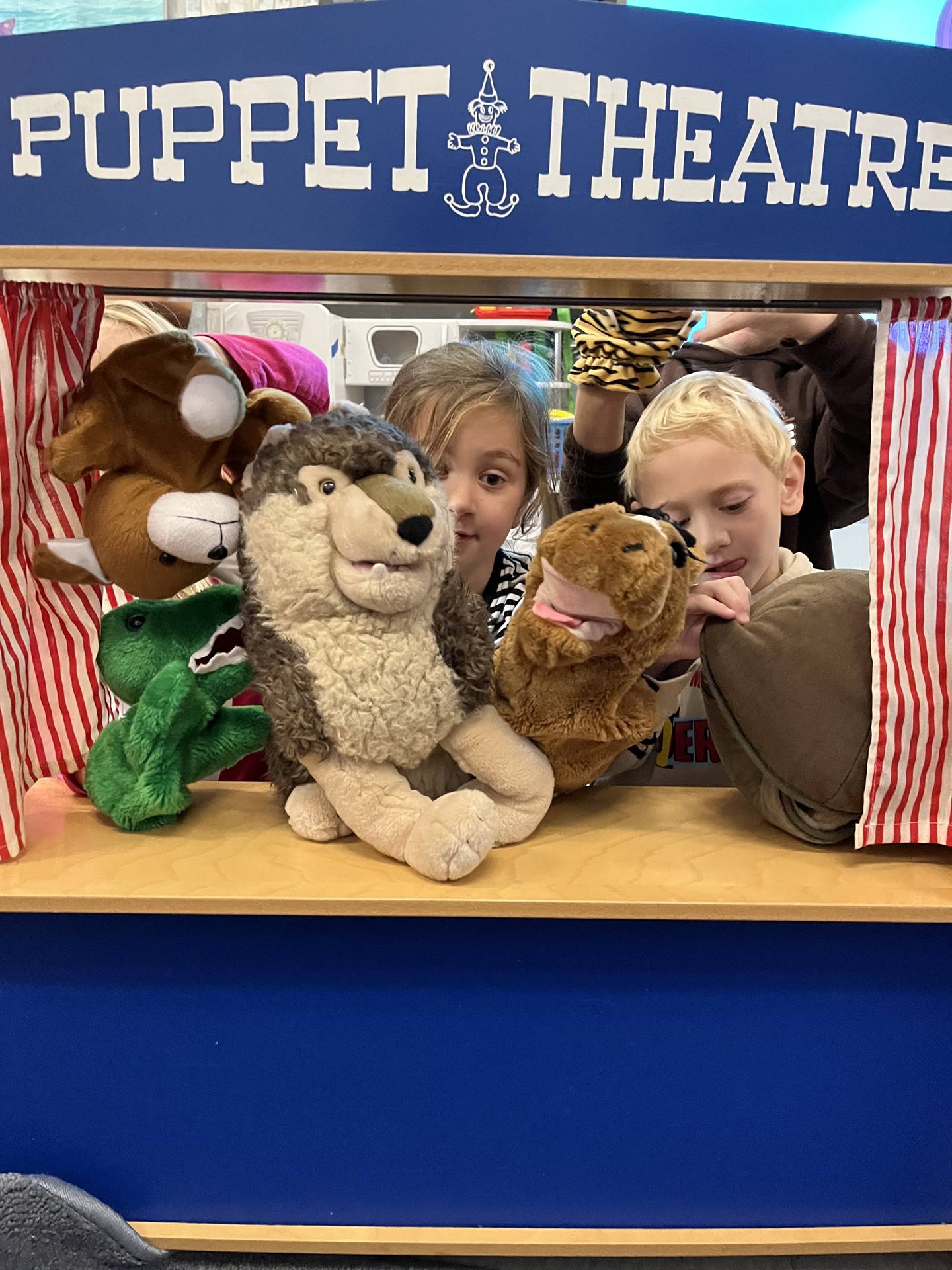 students in puppet theater with puppets