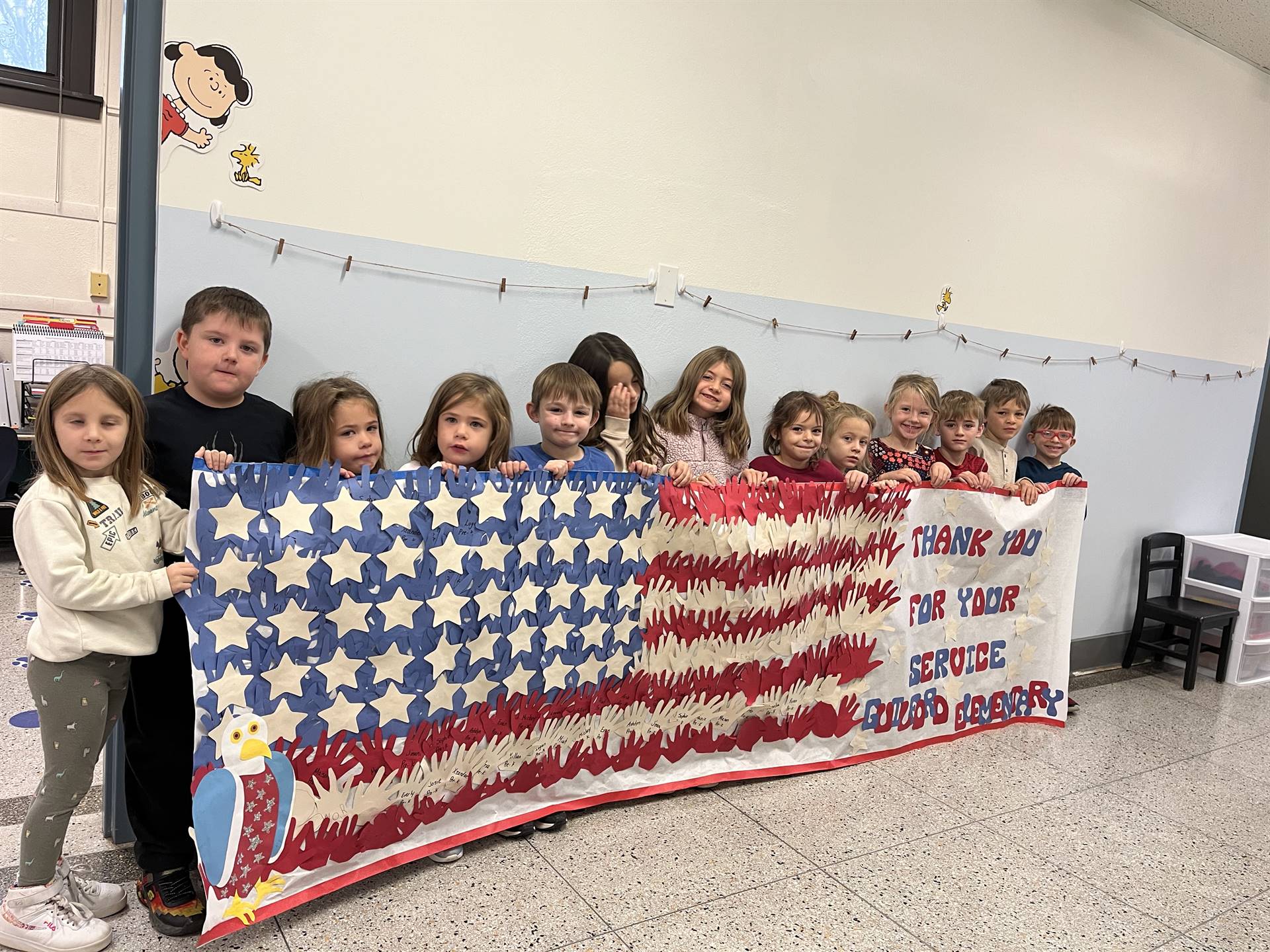 STUDENTS standing behind a large red white and blue banner that is like a flag