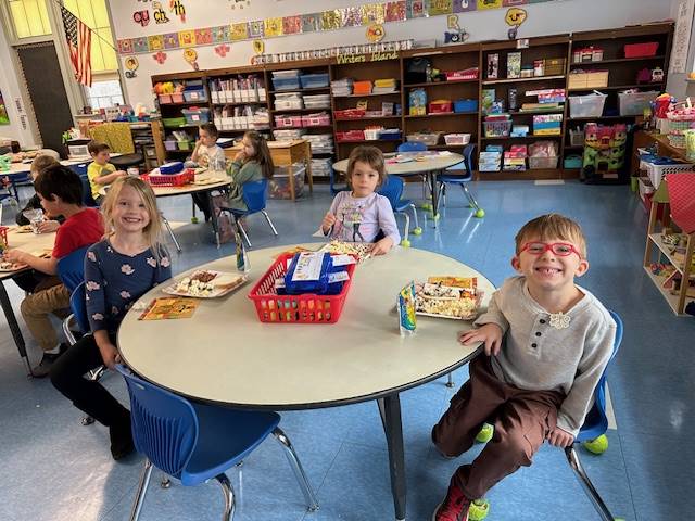 3 students at a table sampling different foods